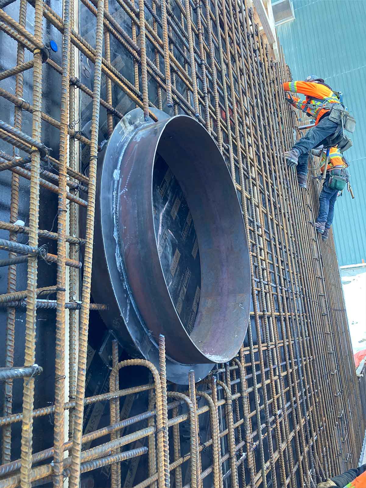 Tall concrete walls being built with large circular opening