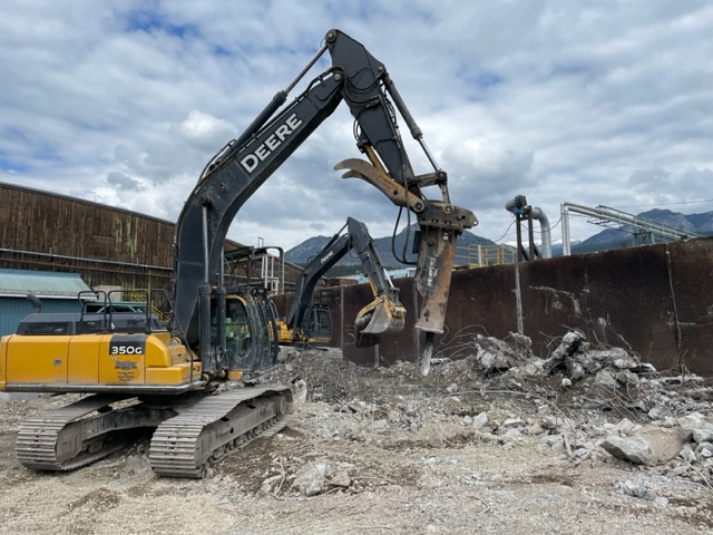 Excavator jackhammering old foundations